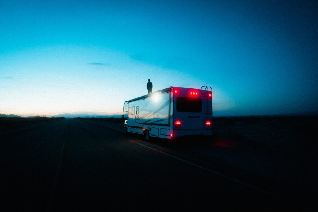 Man Standing on Camper in Evening