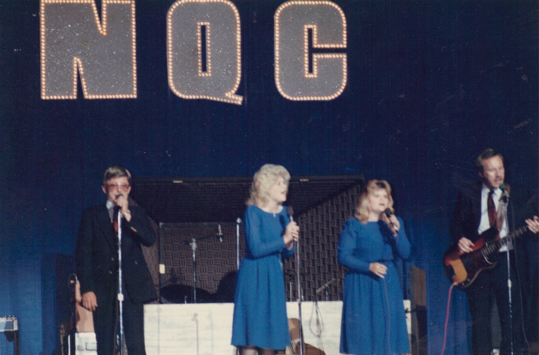 a group of people standing on a stage with microphones